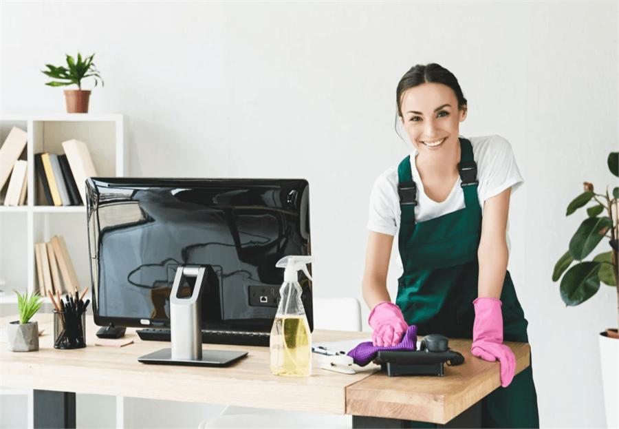 A cleaner wiping down an office desk